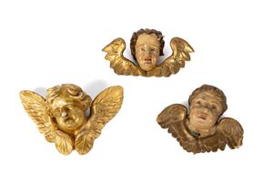 Tre testine di putto in legno laccato e dorato, secoli XVIII-XIX