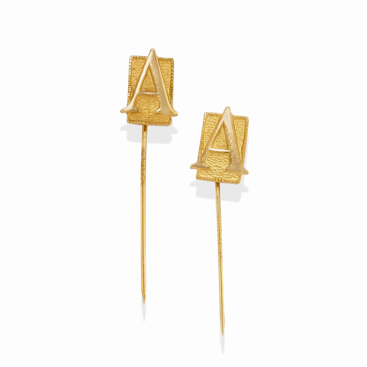 Quattro spille in oro giallo 18k e laminato con smalto policromo