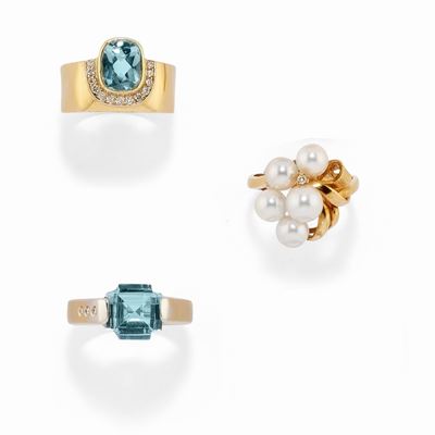 Tre anelli in oro bicolore 18k con topazi azzurri e diamanti