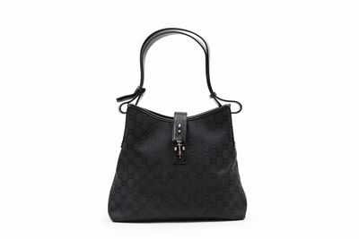 Borsa in tela logata nera con tracolla in pelle e chiusura a pistone in metallo
