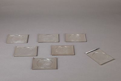 Set di sette sottobicchieri in metallo argentato