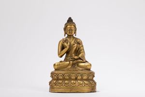 A GILT-BRONZE FIGURE OF A SEATED BUDDHA