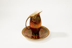 Crown Devon Manufactory, England, 20th century. Jug and plate in polychrome enamelled ceramic with a copper red background.