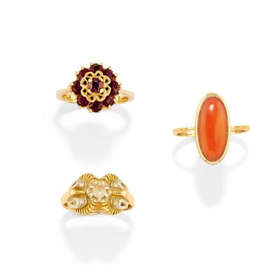Tre anelli in oro giallo 18k con gemme: corallo cabochon, pietre incolori e granati