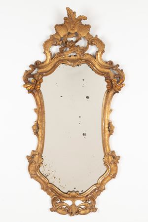 Specchiera di forma mossa in legno intagliato e dorato a volute fogliate, secolo XX