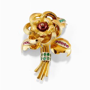 A 18K two-color gold, diamond, emerald, garnet and ruby brooch