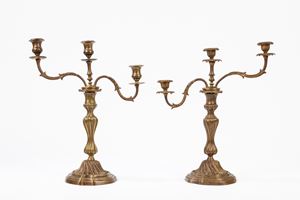 Two antique patined metal three-flame candelabra