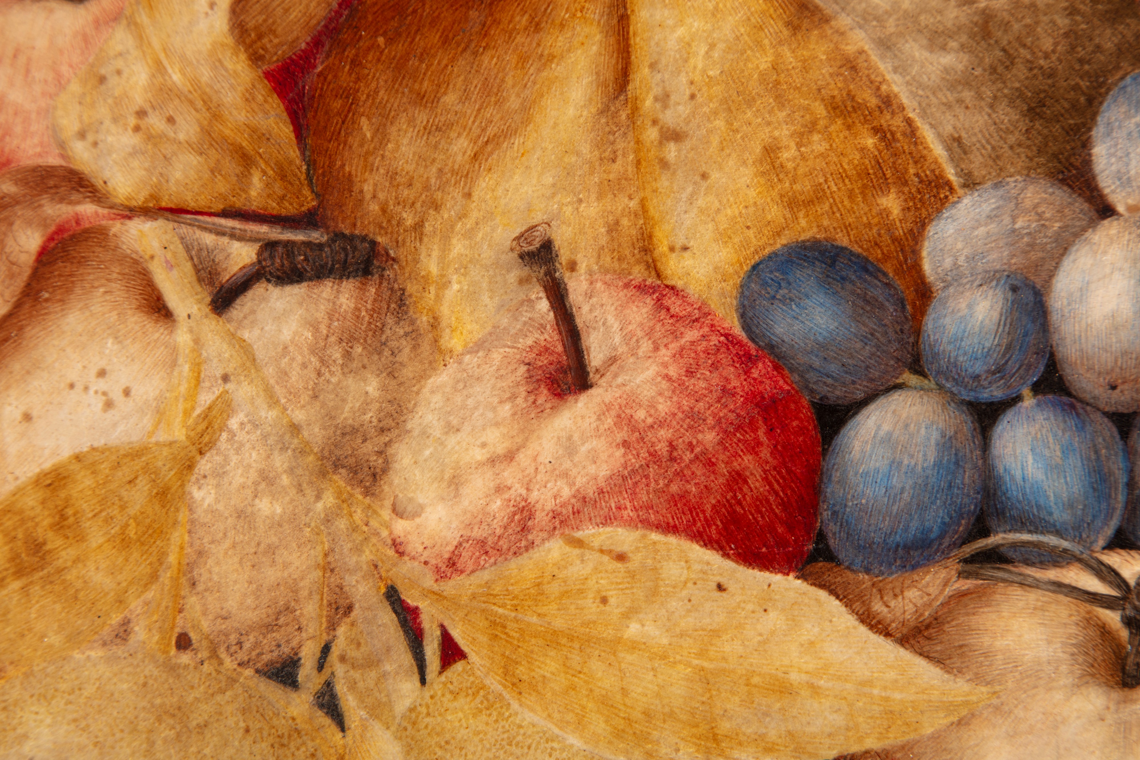 Mele, pere, uva, castagne e altri frutti in un'alzata di ceramica bianca e blu su un piano di pie...