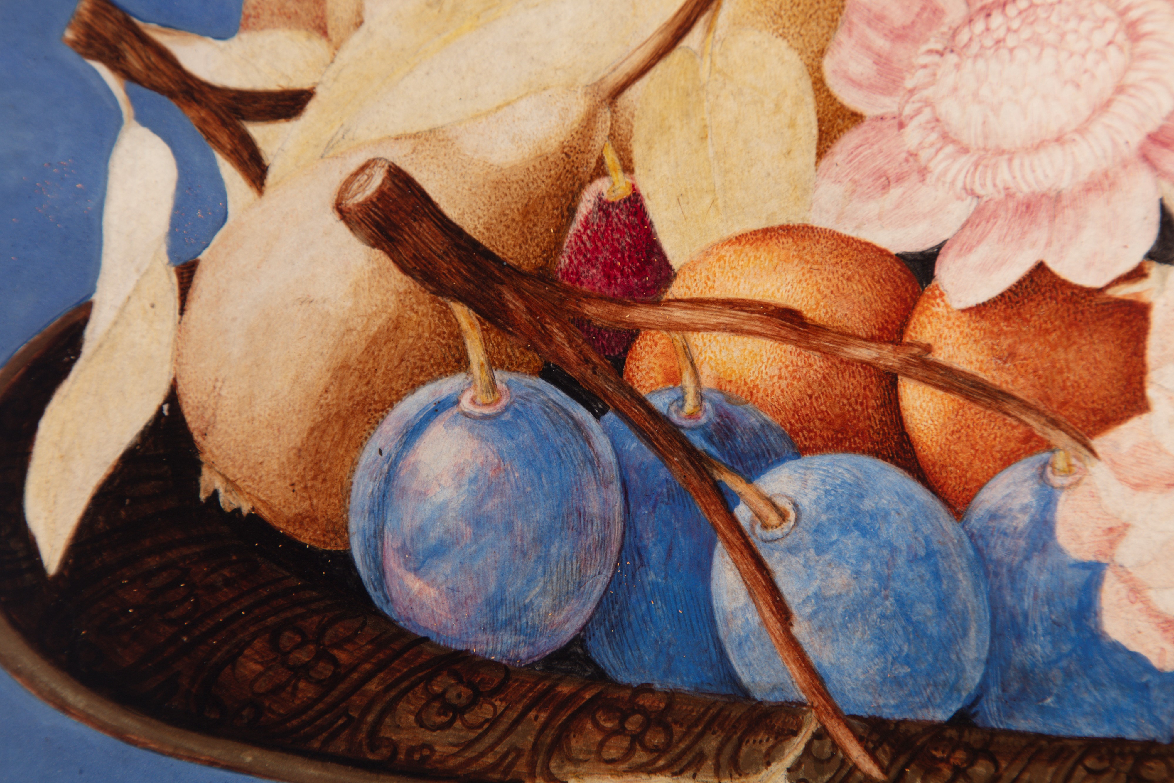 Pere, prugne, albicocche, altri frutti e fiori in un'alzata su un piano di pietra