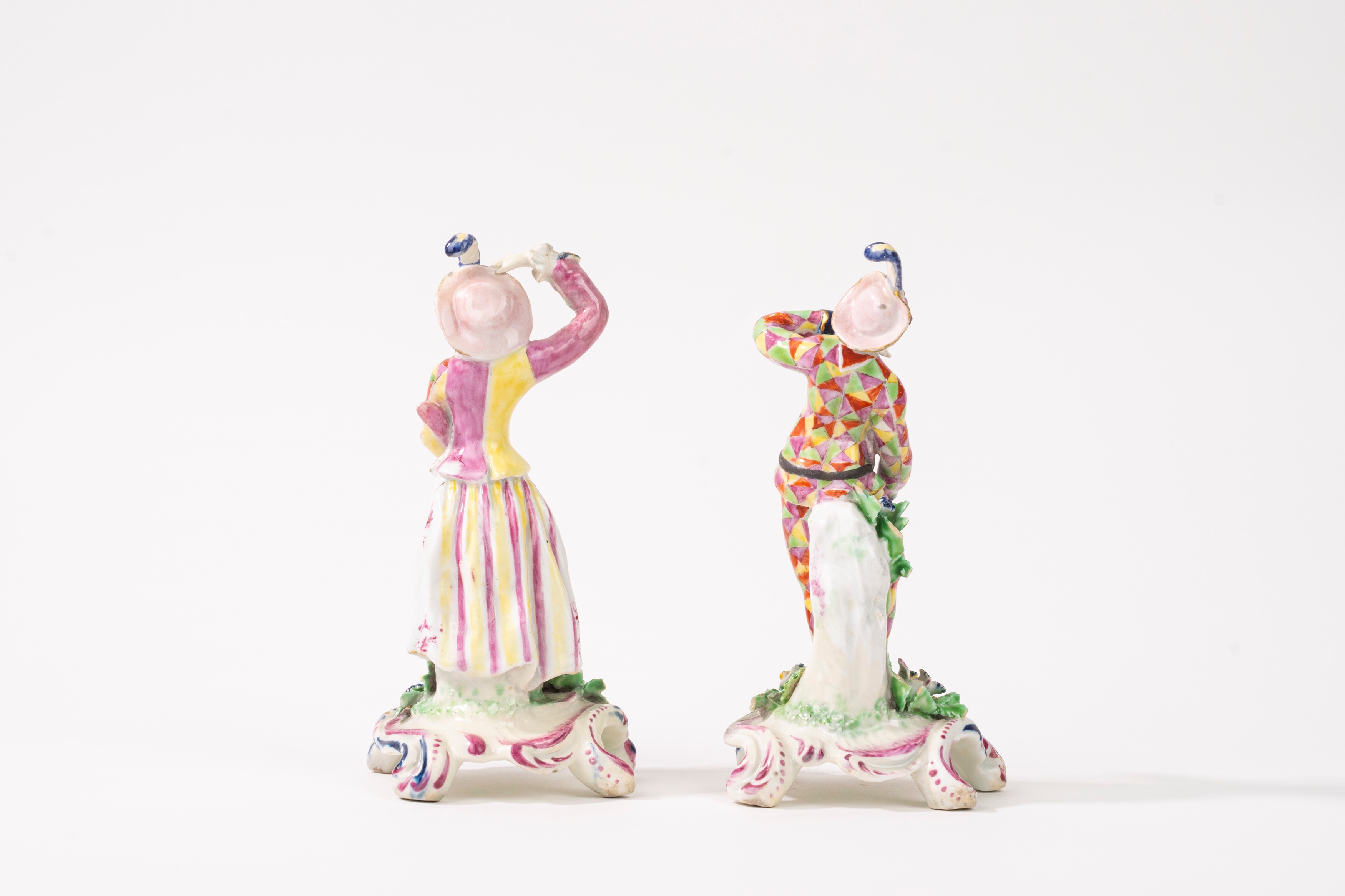 Due statuette raffiguranti Arlecchino e Colombina in porcellana policroma, secolo XIX-XX