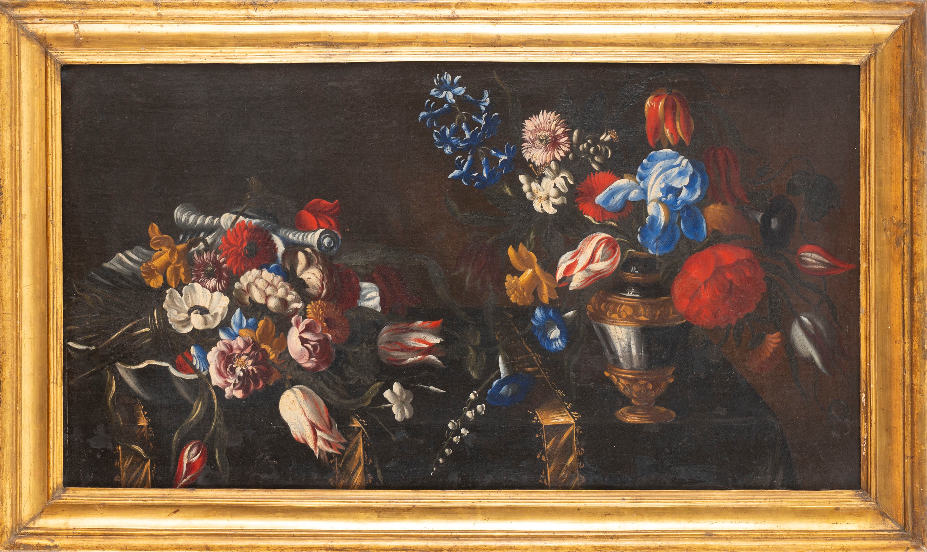 Tulipani, iris, garofani ed altri fiori in un vaso su un tavolo