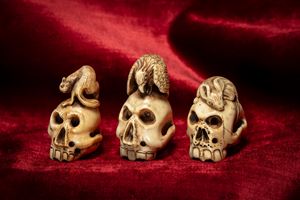 Tre netsuke in avorio intagliato e traforato a guisa di teschi sormontati da un topolino, un'aquila e una volpe. Giappone, periodo Meiji (1868-1912)