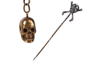 One gold pill box shaped as a skull (g 10; cm 2) and a gold and silver tie clip with skull (g 9; cm 8)
