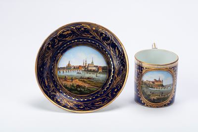 Manifattura di Meissen, Tazza con piattino in porcellana policroma con vedute di Meissen e Dresda...