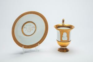 Rara tazza con piattino in porcellana bianca e in oro lucido e opaco con profilo in biscuit. Manifattura di Meissen, 1817-1818