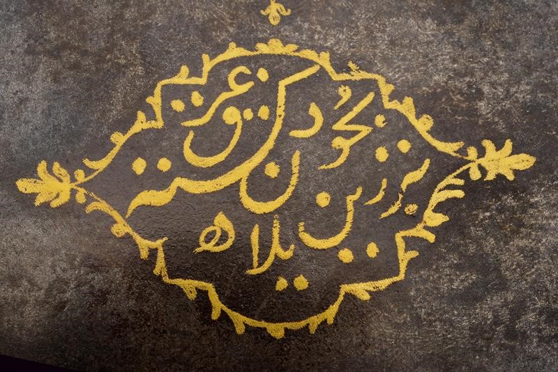 Testa di tabar con decorazioni ed iscrizioni in oro