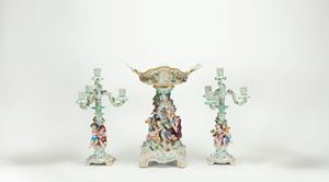 Lotto composto da un'alzata e una coppia di candelabri in porcellana policroma. Manifattura di Meissen, fine secolo XIX
