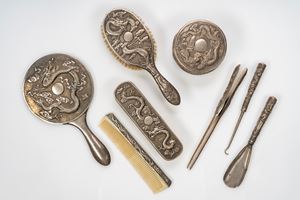 Toilet set of eight pieces in repoussé and chiseled silver with dragon and cloud motifs, China, late Qing dynasty