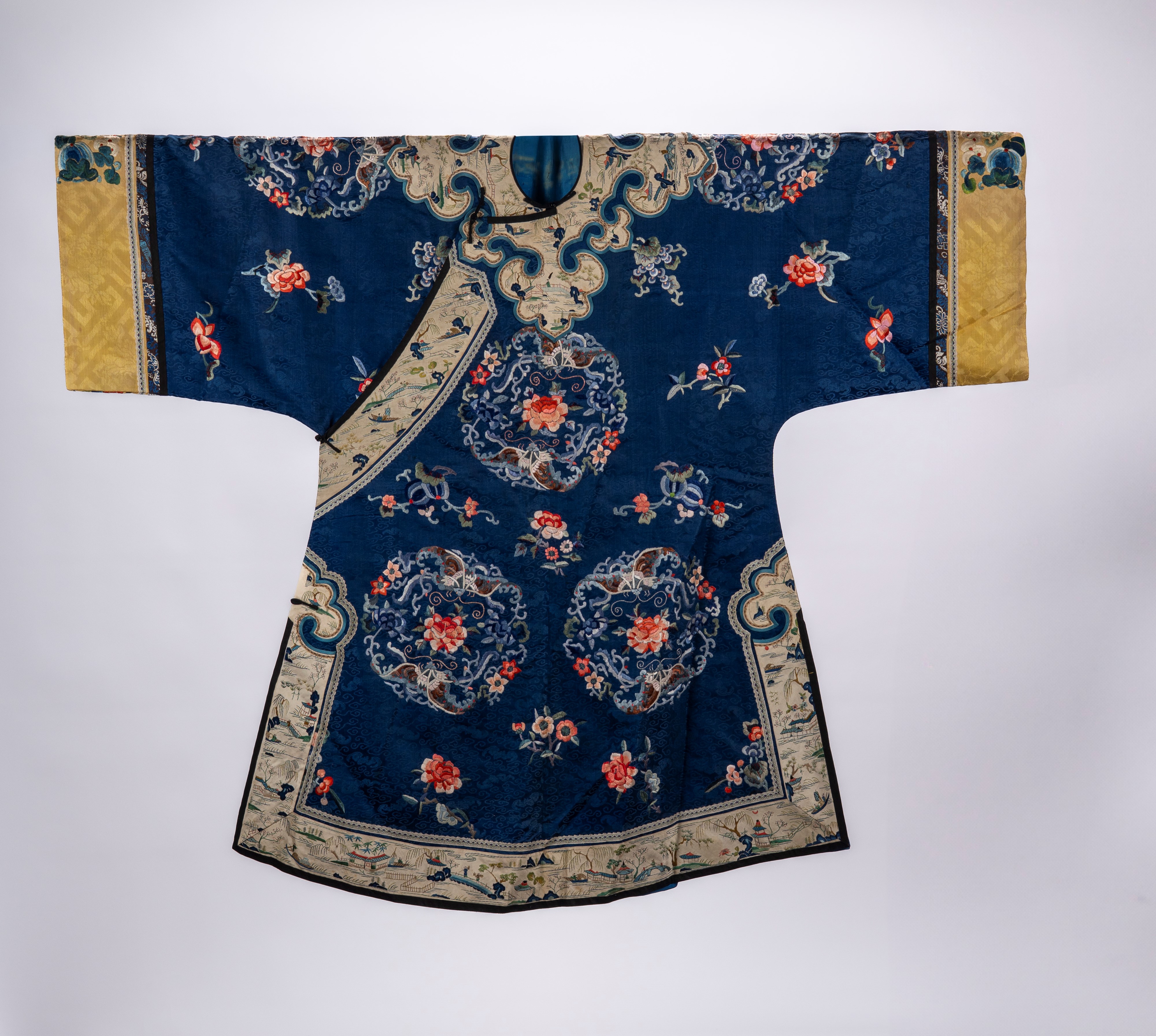 Lot of two blue-ground silk robes, one decorated with floral, ruyi and ...