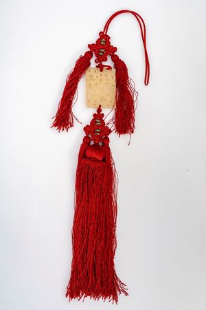 Pierced jade plaque depicting a Foo dog, with red tassels, China, 20th century