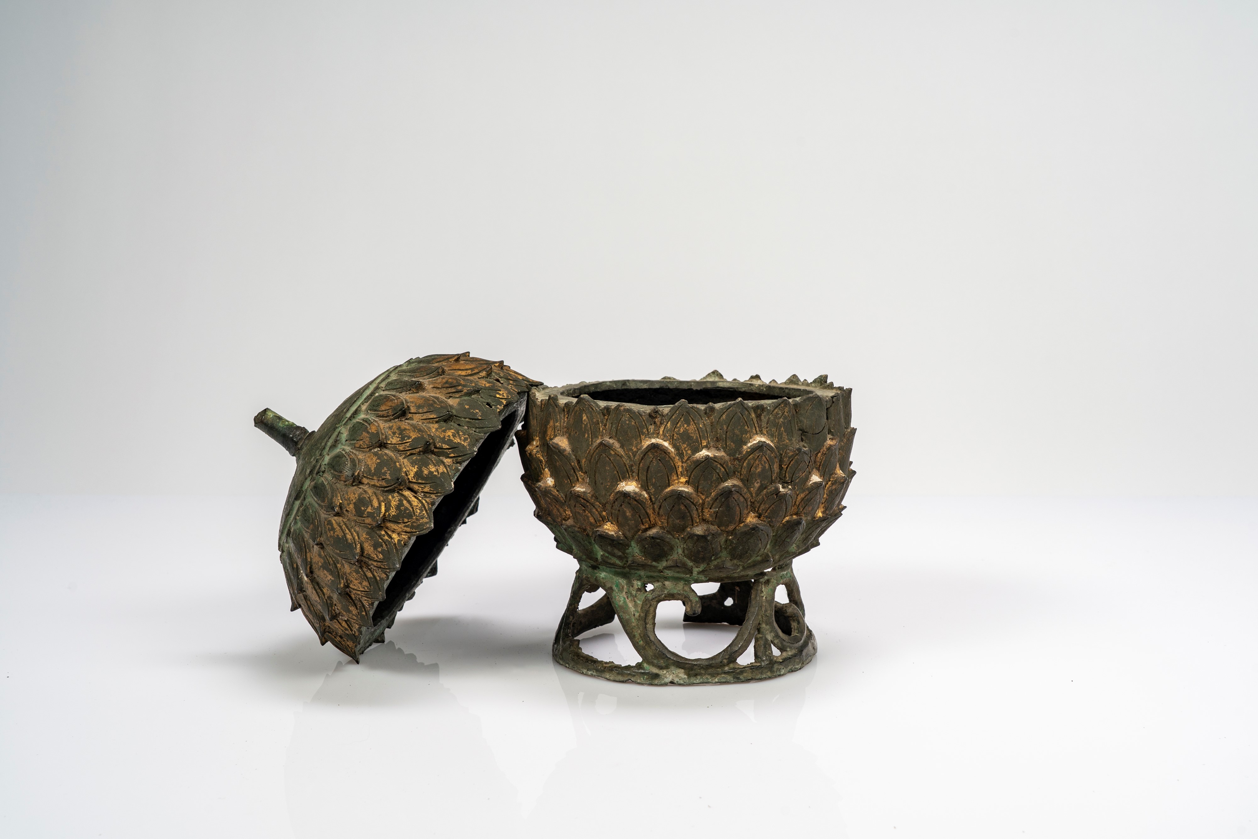 Contenitore in bronzo con coperchio, con tracce di doratura e a forma di pigna. Cina, dinastia Qi...