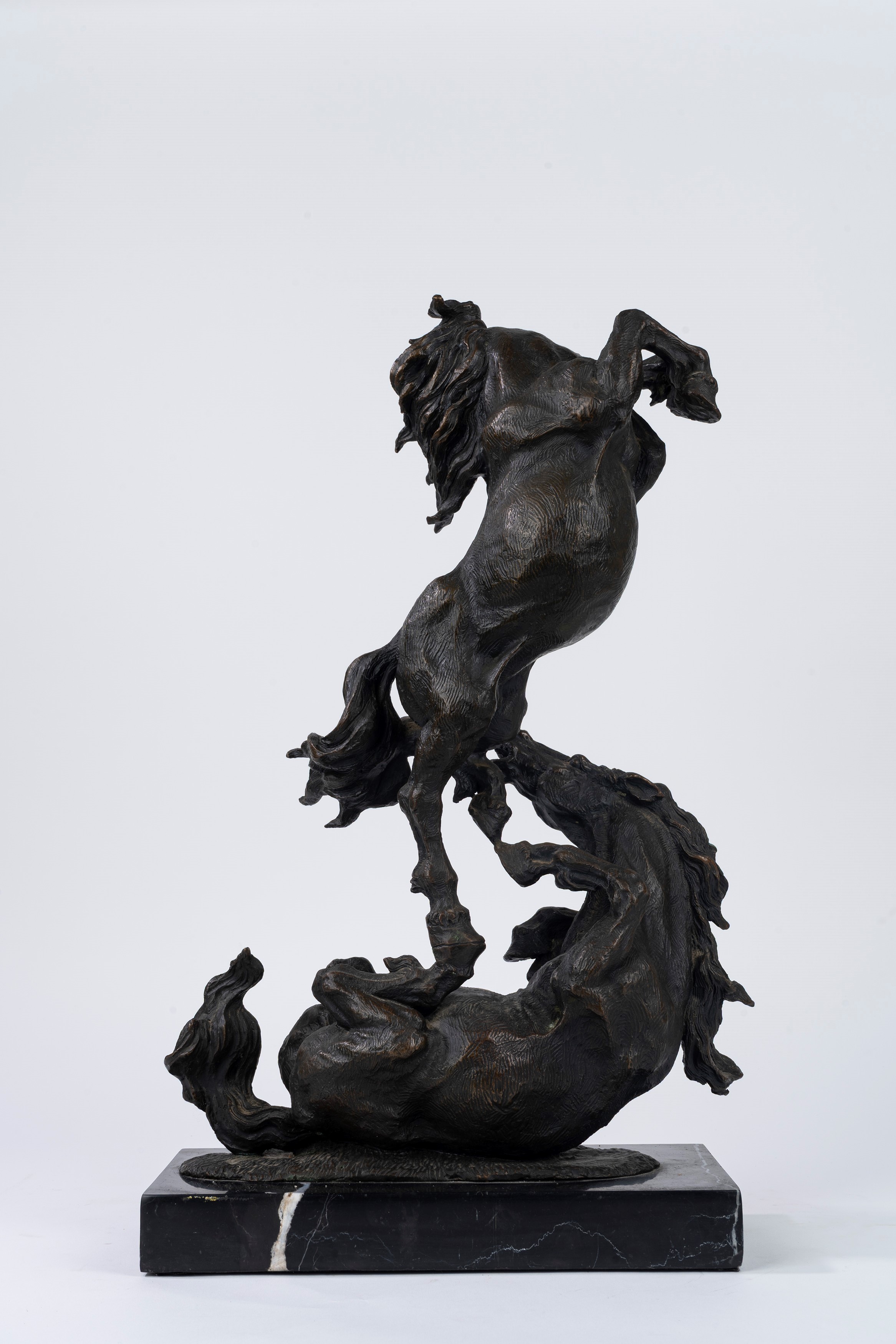 Scultura in bronzo a patina scura, raffigurante due cavalli che lottano, secolo XX