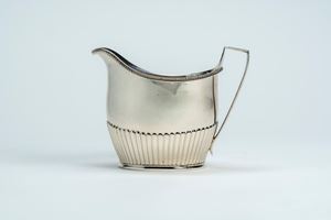 Lattiera in argento 925 a corpo liscio e costolato con ansa sagomata. Londra, 1800