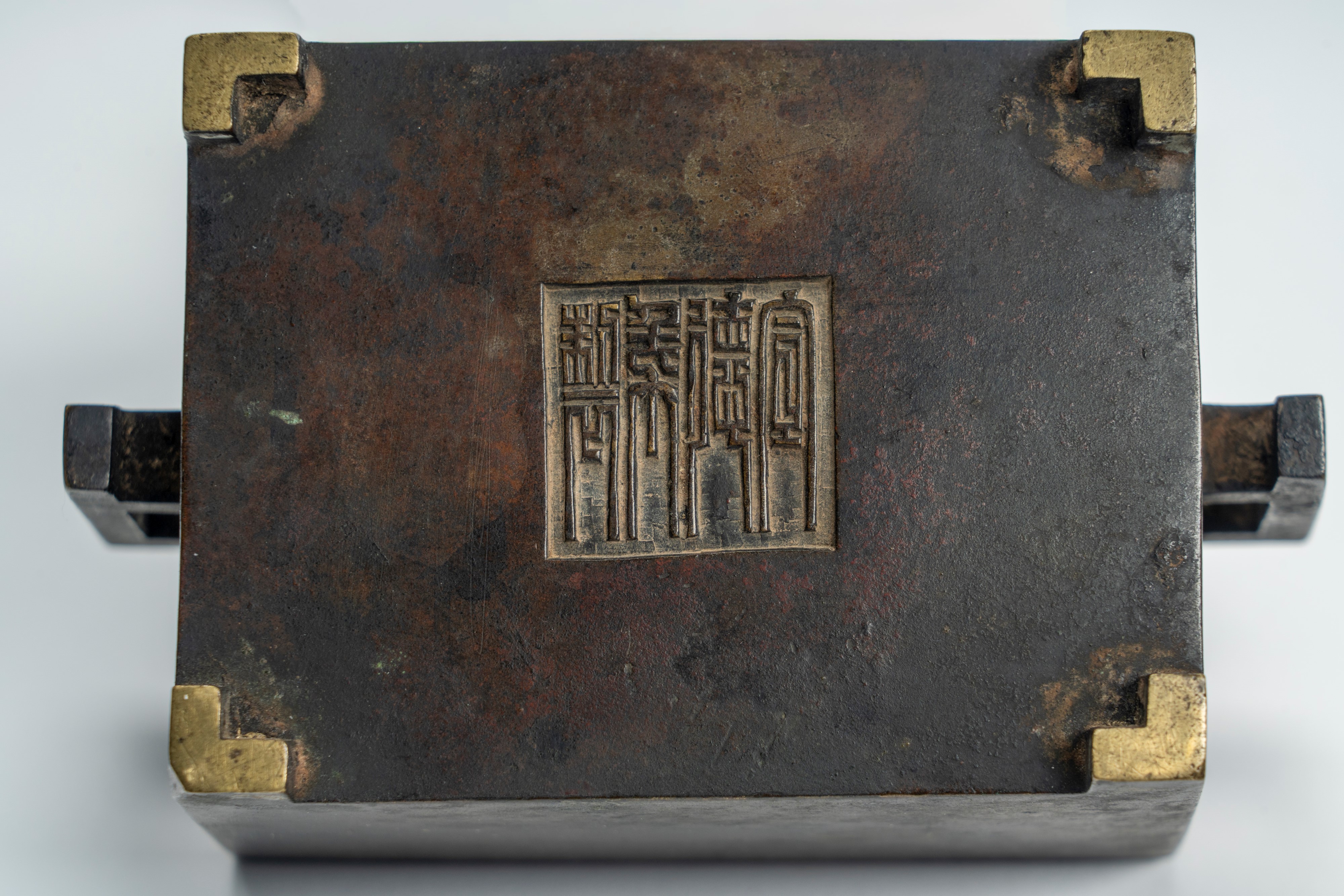 Piccolo incensiere biansato in bronzo, di forma squadrata, recante marchio apocrifo Xuande. Cina,...