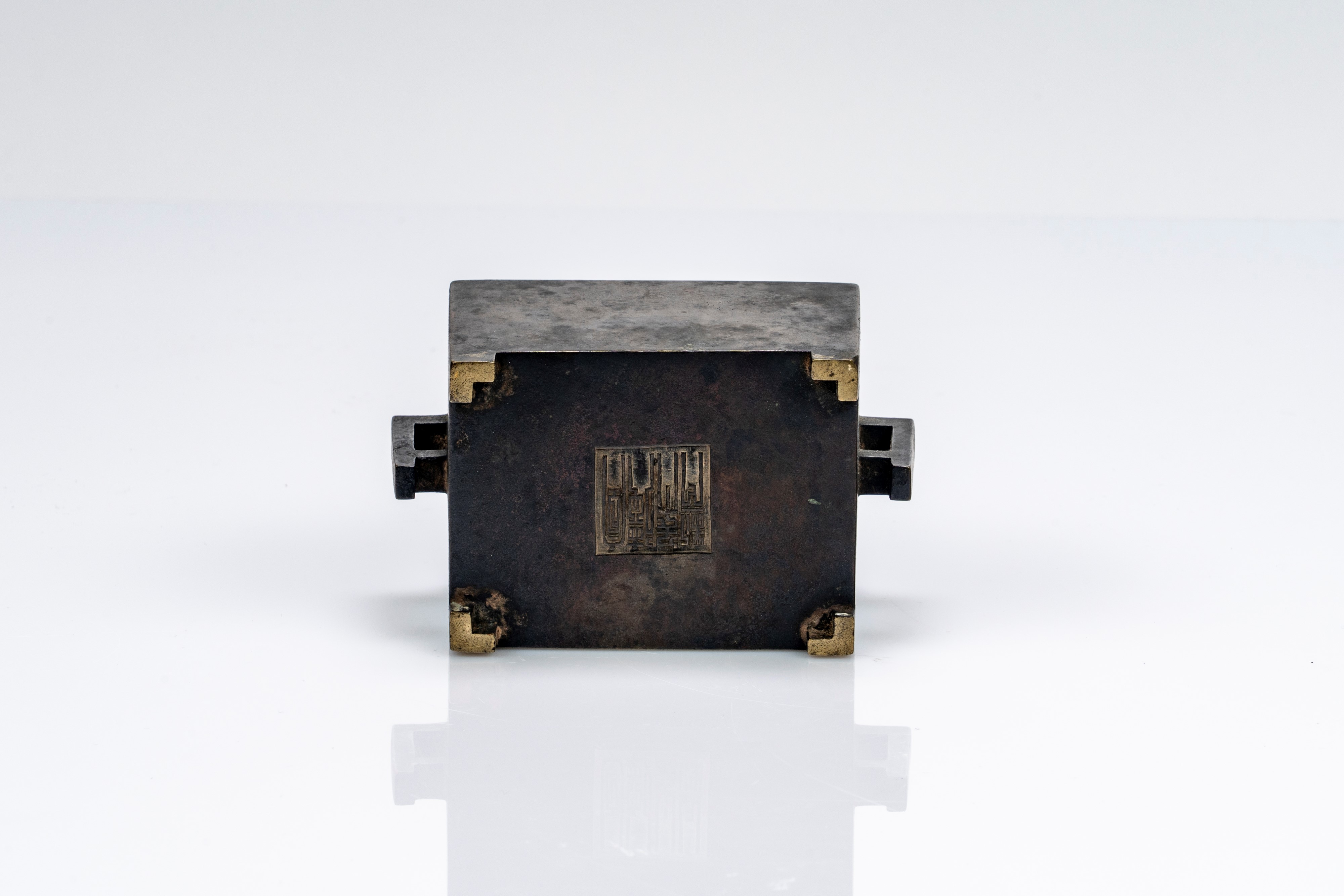 Piccolo incensiere biansato in bronzo, di forma squadrata, recante marchio apocrifo Xuande. Cina,...