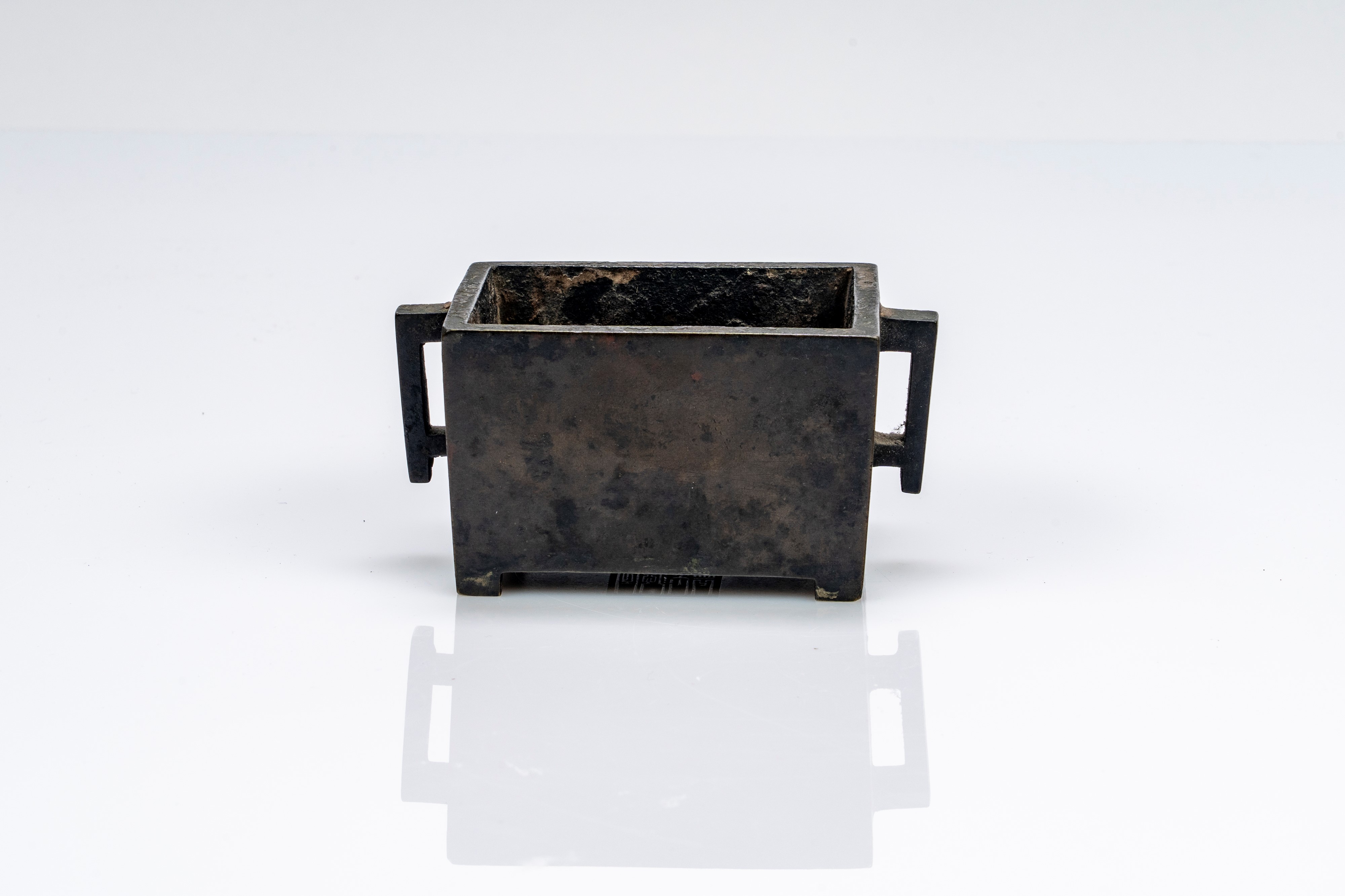 Piccolo incensiere biansato in bronzo, di forma squadrata, recante marchio apocrifo Xuande. Cina,...