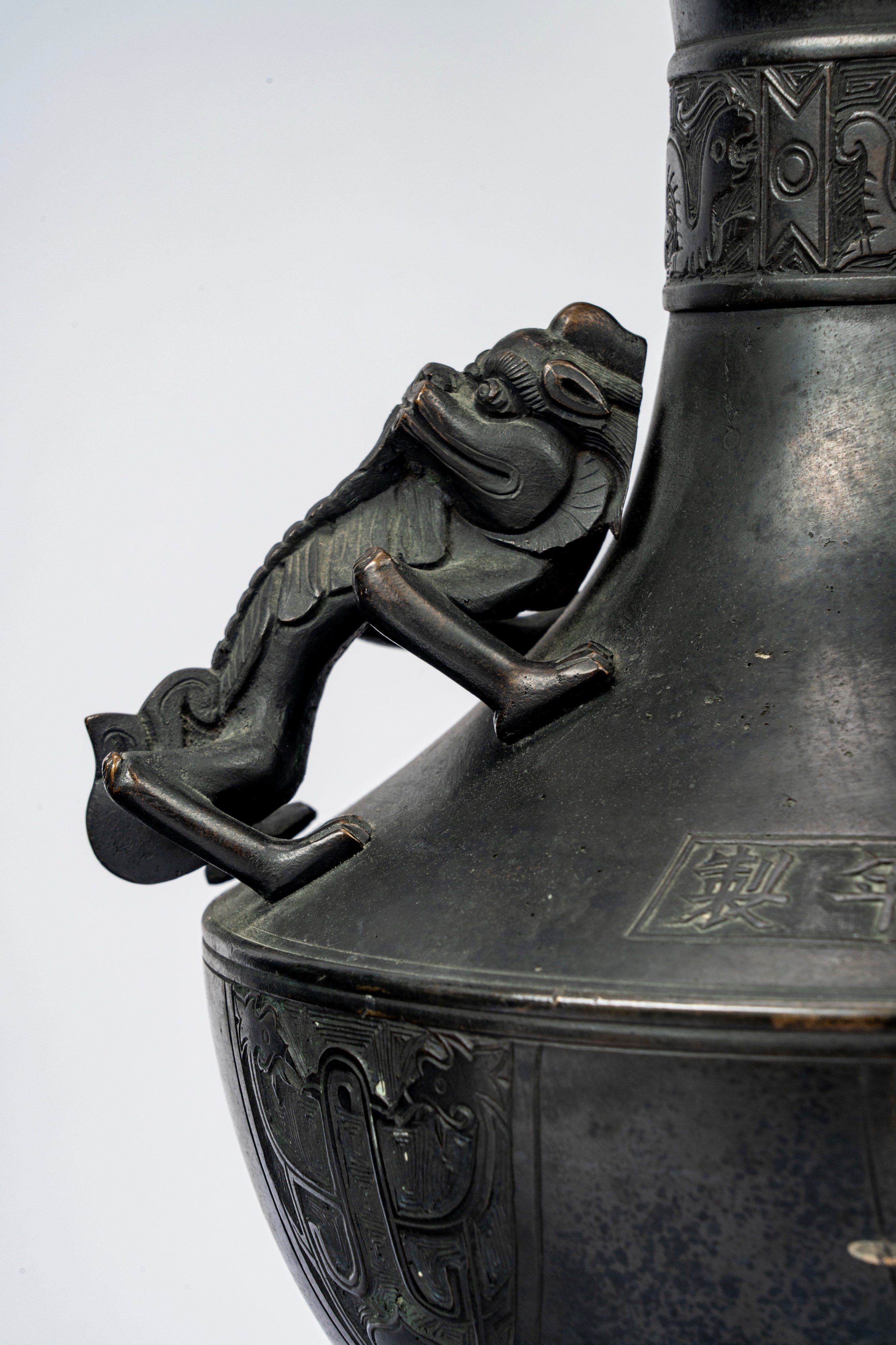 Coppia di vasi biansati in bronzo cesellati a motivo di fenici stilizzate e qilin, recanti marchi...