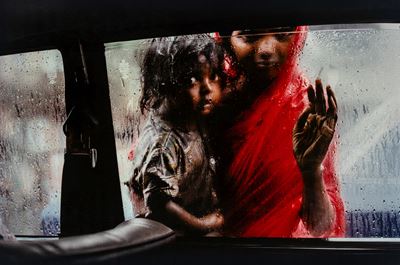 Mother And Child At Car Window, India