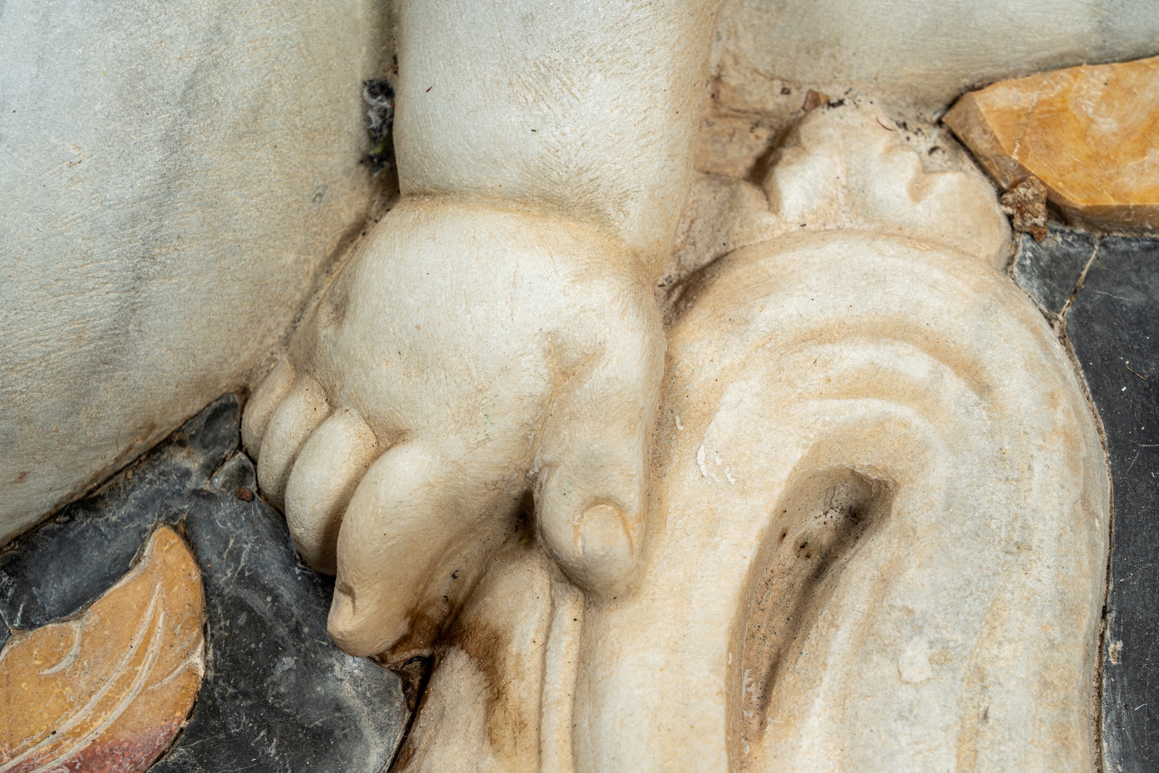 Importante pannello a tecnica mista in marmo scolpito e intarsiato raffigurante putto tra girali ...