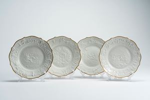 Quattro piatti in porcellana bianca a basso rilievo con profilo mistilineo dorato. Manifattura di Capodimonte, fine XIX secolo