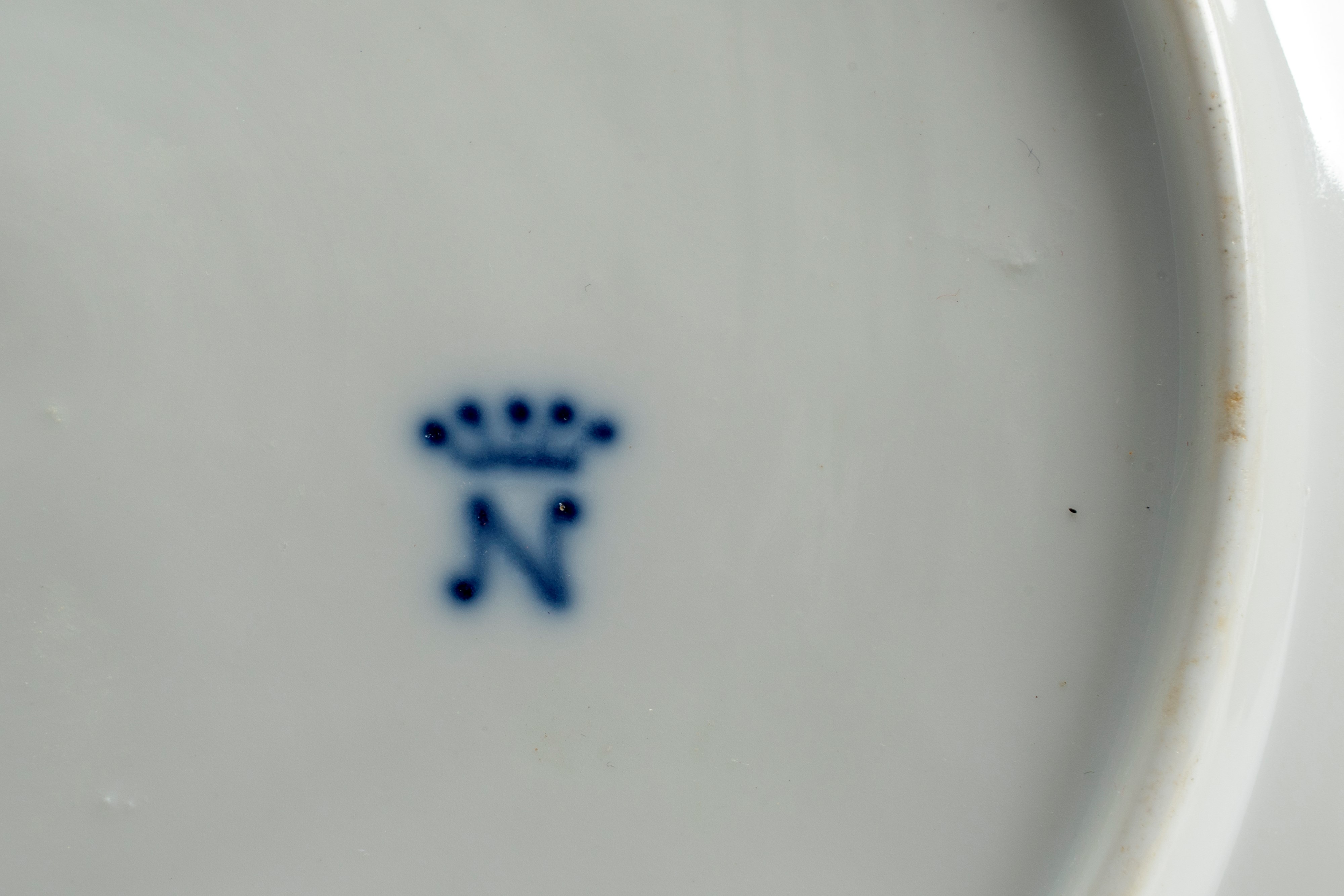 Quattro piatti in porcellana bianca a basso rilievo con profilo mistilineo dorato. Manifattura di...