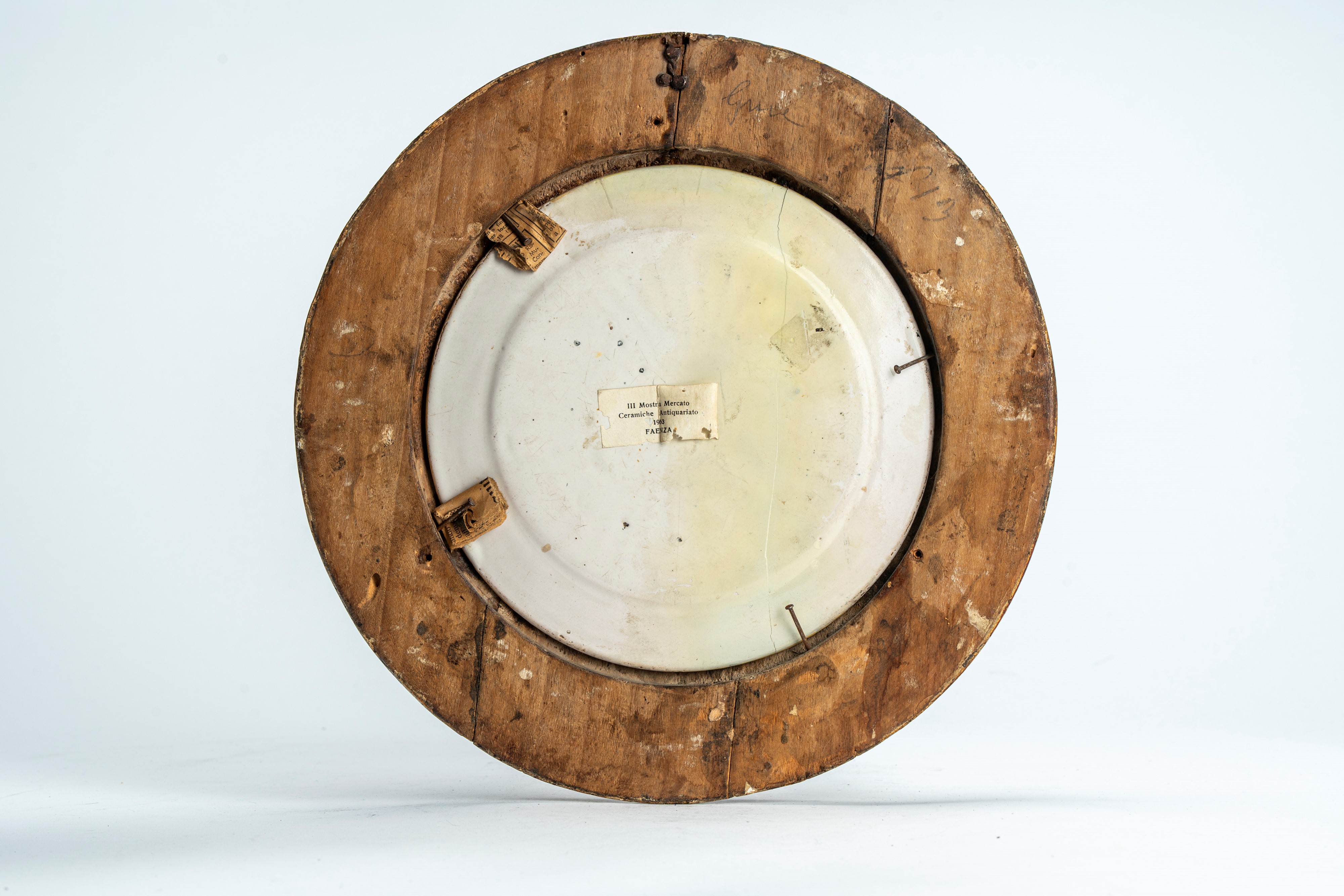 Piattello in maiolica policroma istoriata con putto alato musicante in un paesaggio agreste con s...