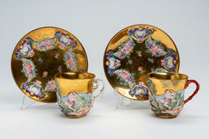 Coppia di tazzine con piattino in porcellana a fondo dorato e a rilievo. Manifattura Ginori, seconda metà secolo XIX