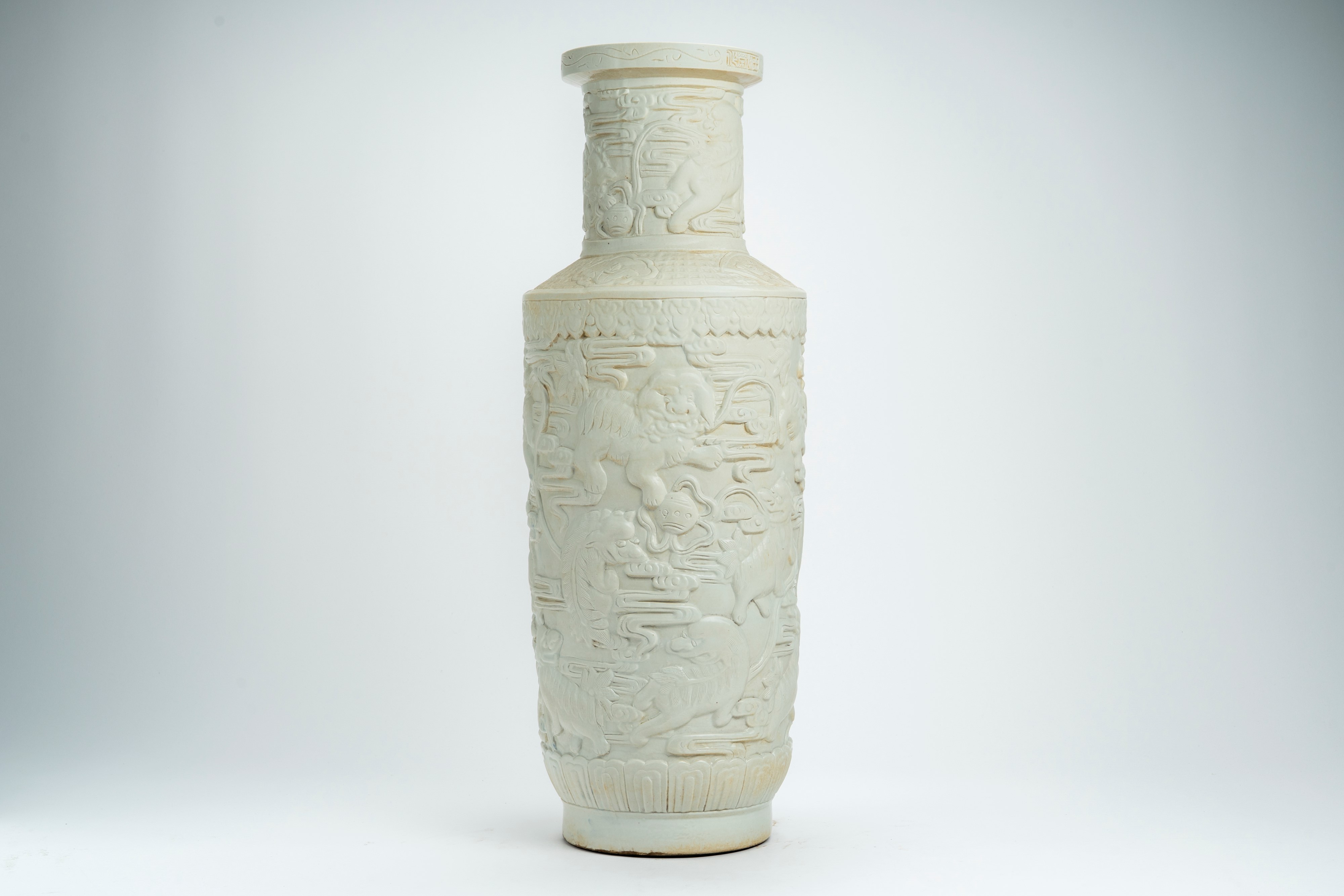 Grande vaso rouleau in porcellana bianca, decorato a rilievo con animali fantastici, nuvole e mot...