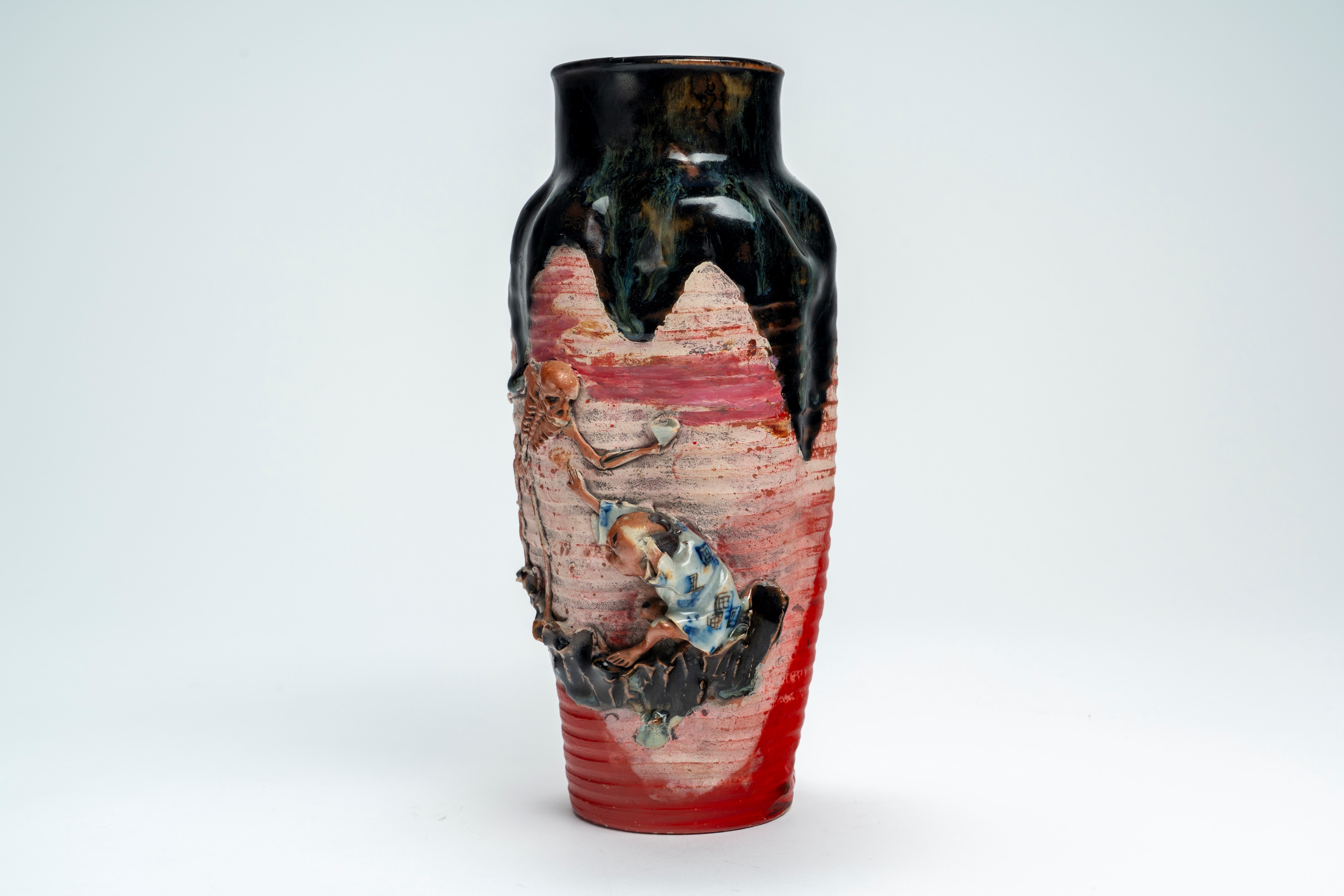 Vaso in ceramica policroma decorato a rilievo con figura di scheletro e fanciullo, recante marchi...
