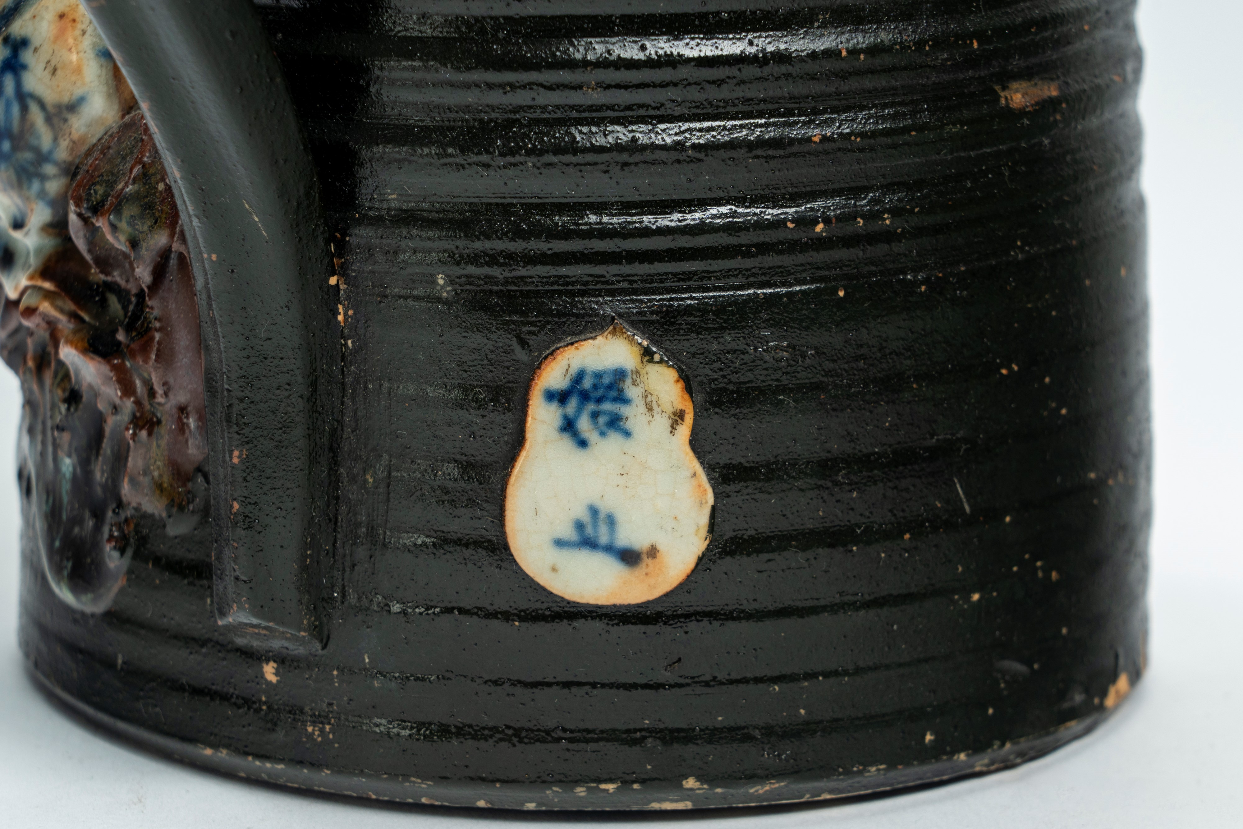 Versatoio in ceramica policroma decorato con figure a rilievo recante marchio entro doppia zucca ...