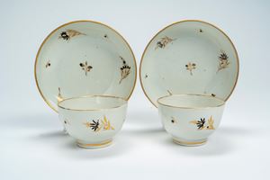 Coppia di tazze con piattino in porcellana decorata in oro e nero a rametti di fiori sparsi. Chamberlain Worcester, fine secolo XVIII