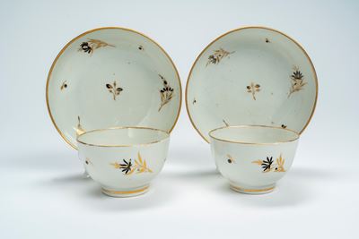 Chamberlain Worcester, Coppia di tazze con piattini in porcellana decorata in oro e nero a ramett...