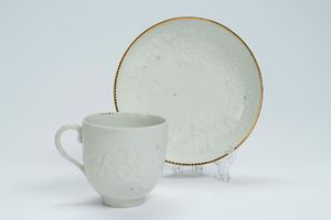 Tazza con piattino in porcellana bianca a rilievo. Inghilterra, manifattura di Derby, fine secolo XVIII