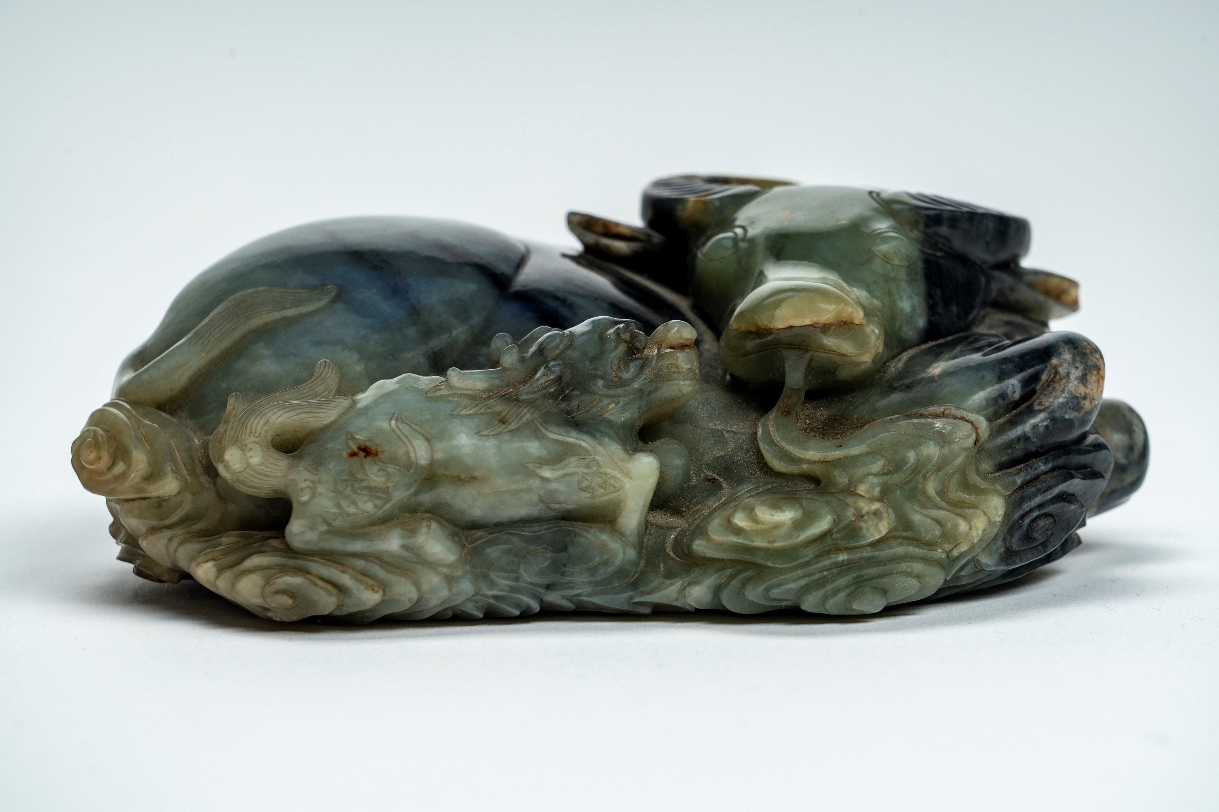 Intaglio in giada marezzata e con russet raffigurante bufalo accovacciato con cane di Fo. Cina, s...