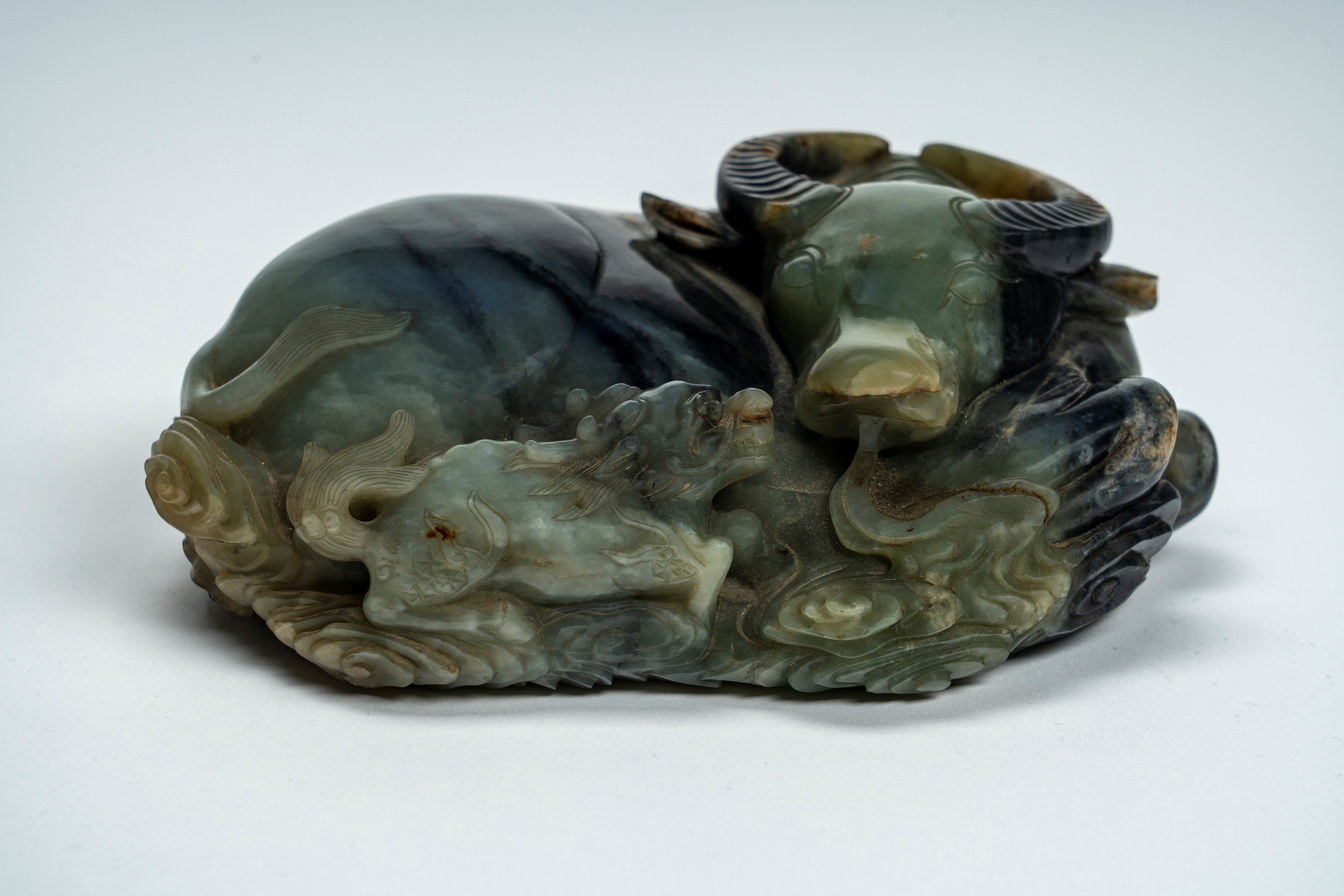 Intaglio in giada marezzata e con russet raffigurante bufalo accovacciato con cane di Fo. Cina, s...