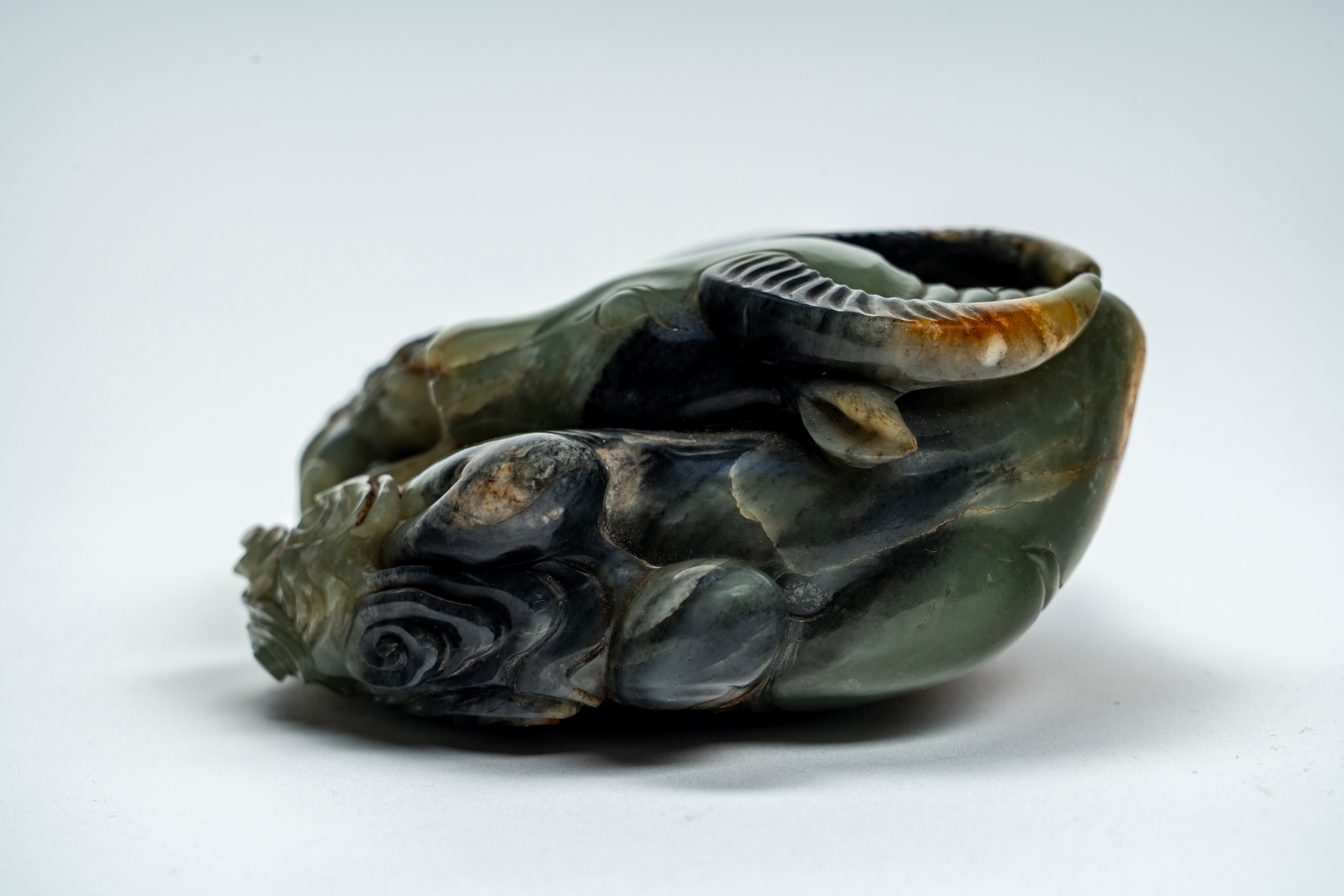 Intaglio in giada marezzata e con russet raffigurante bufalo accovacciato con cane di Fo. Cina, s...