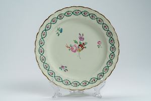 Piatto a profilo mosso e dorato in porcellana con decoro policromo alla rosa e ghirlanda intrecciata. Derby, fine secolo XVIII