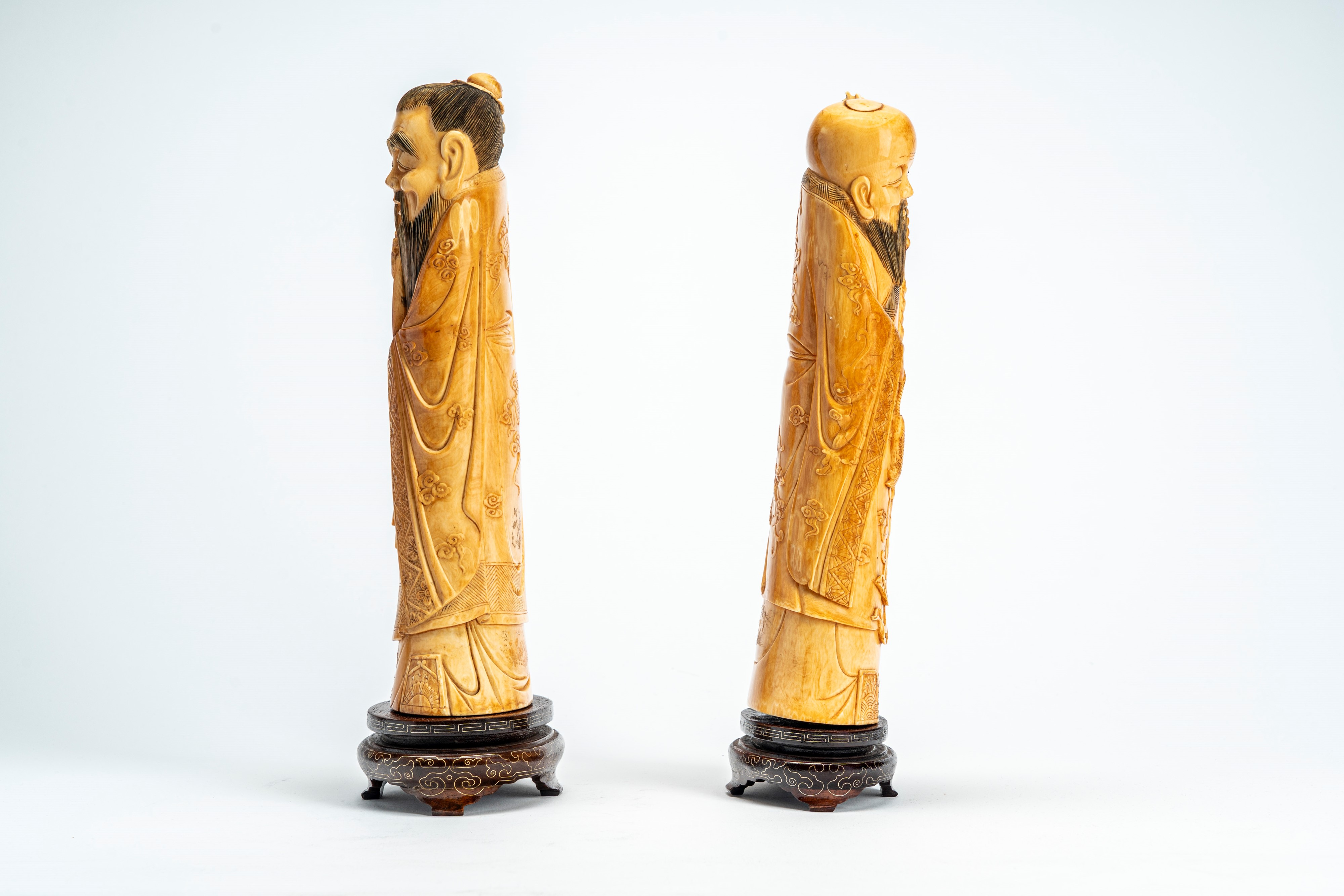 Cina, Coppia di sculture in avorio raffiguranti saggi con bastone e strumento musicale, inizi XX ...