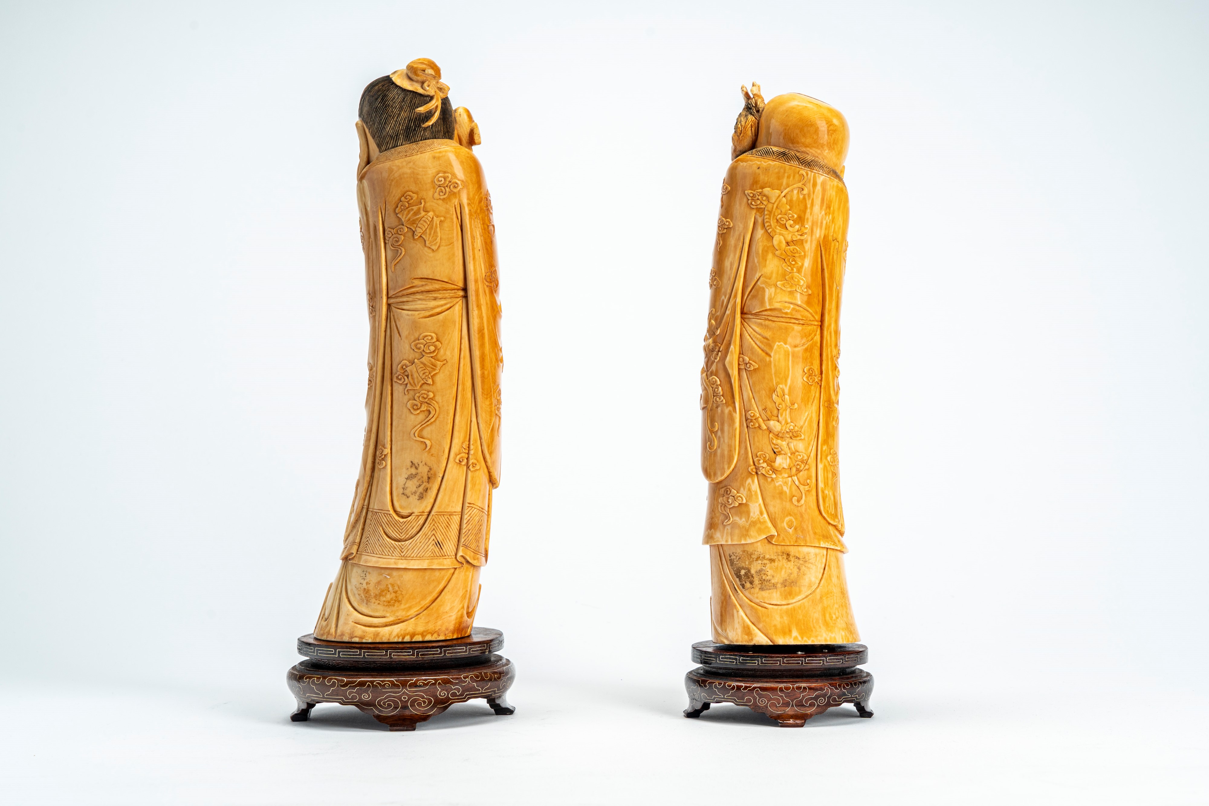 Cina, Coppia di sculture in avorio raffiguranti saggi con bastone e strumento musicale, inizi XX ...