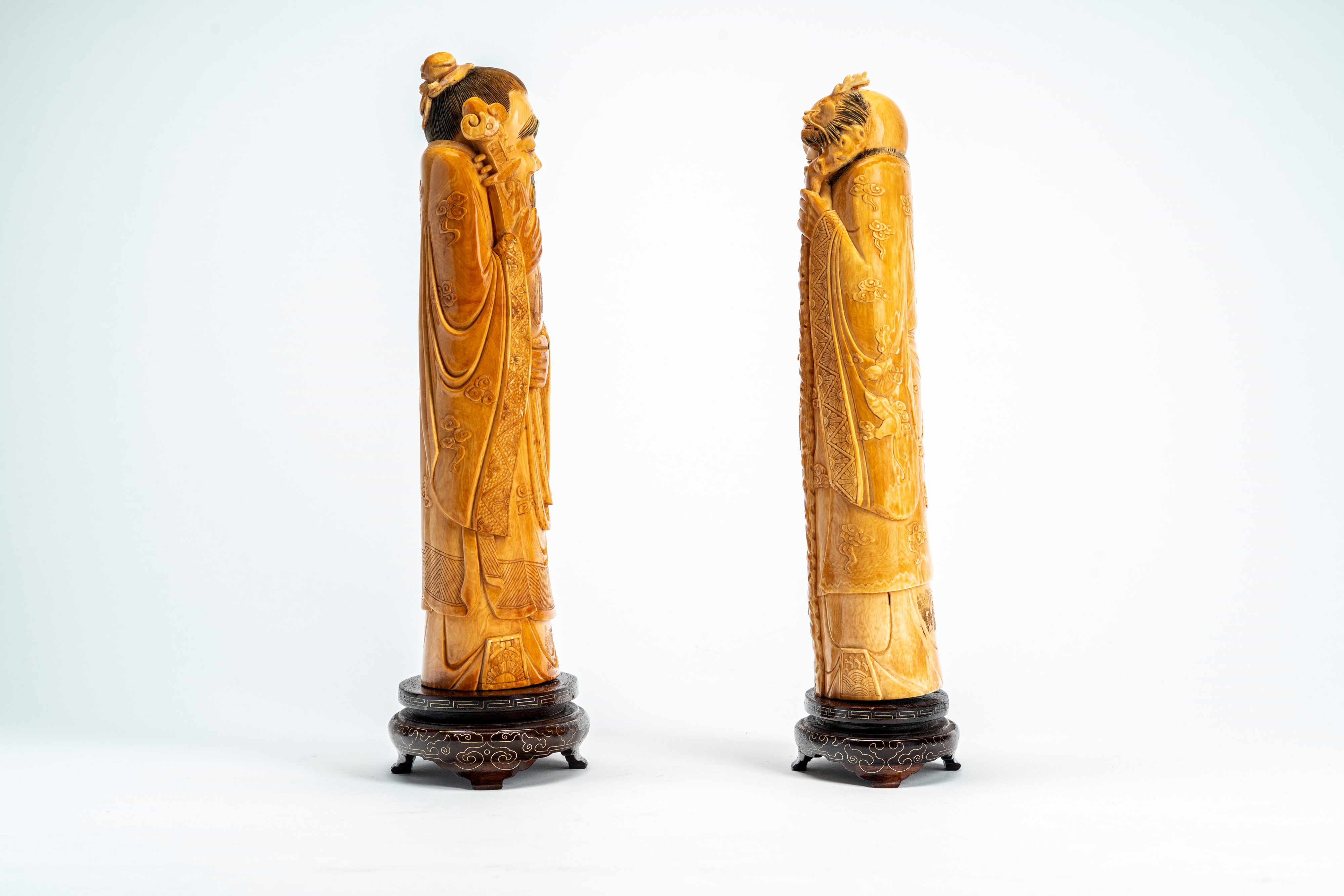 ☼ Coppia di sculture in avorio raffiguranti saggi, uno con bastone e l’altro con strumento musica...